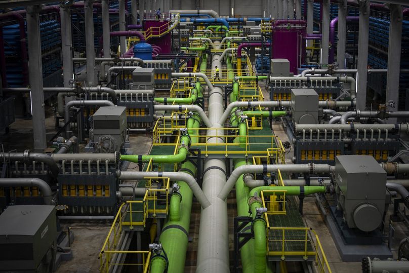 A worker walks over the pipeline that transports seawater to filters at Europe's largest desalination plant for drinking water in Barcelona.